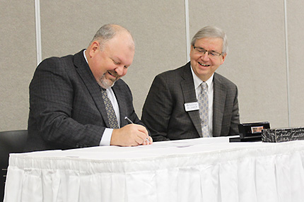 Anthea Schroeder Local 669 Business Manager Brian Dunn (left) and WCC Vice President and Chief Financial Officer William Johnson sign the contract that extends the two parties’ apprenticeship training program through 2022.