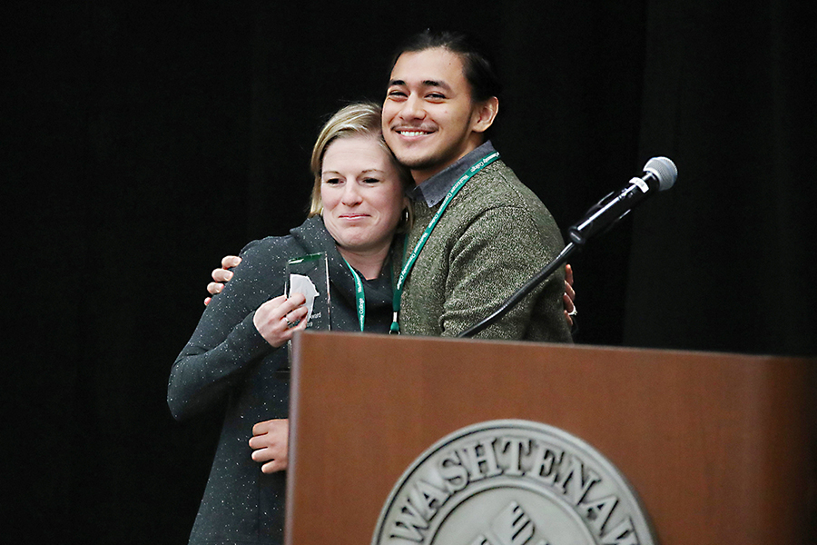 WCC student Pablo Garcia presents the WCC Bridge Award to Huron High School counselor Caitlin Van Cleve.