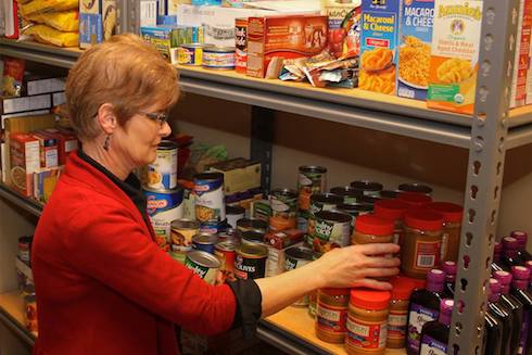 Carol Tinkle stocks the shelves of the WCC food pantry.