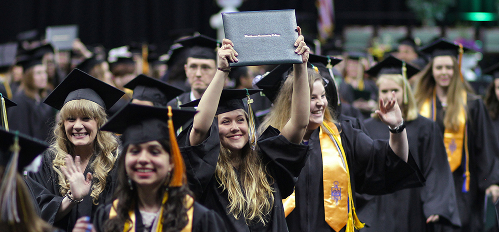 WCC graduate holding up diploma