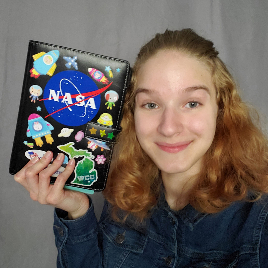 Emilee Seghi holding planner with NASA logo